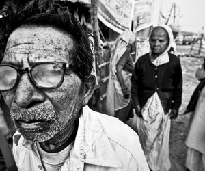 A man from rural West Bengal waits for his son near a makeshift tent