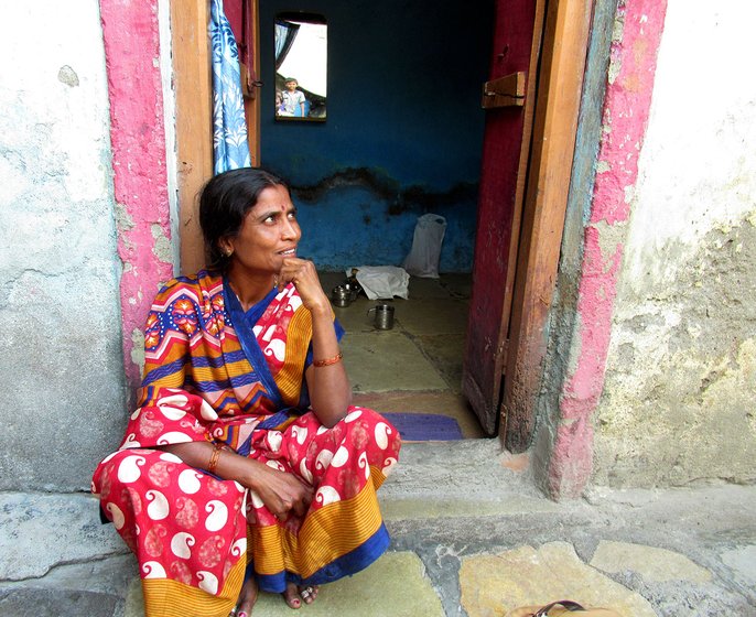 Kavita Kamble sitting outside the doorway of her house