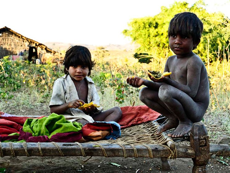 In Attha village, Amashia Budla, 6, and his little sister, Retli, eat rotis made the previous day. Most of the villagers eat leftover rotis the next morning with crushed red chilli and edible oil