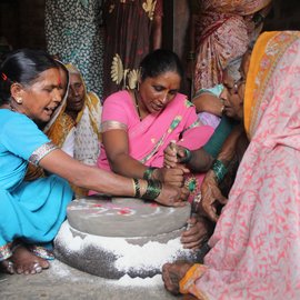 Women sitting by the grinding stone