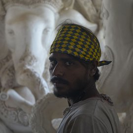 Babban standing in front of idols