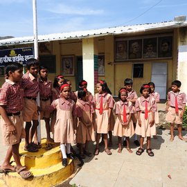 Children singing outside a school.