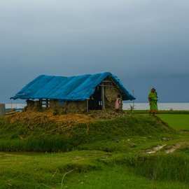 Purnima Mondal, 46, of Kakdwip island, Kakdwip block, South 24 Parganas standing in front of her thatched house with one of her children. Her husband, Provas Mondal, 52, is a construction worker in Nashik, Maharashtra. She catches fish and crabs from nearby rivers everyday. 

